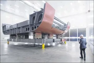  ?? THE CANADIAN PRESS/ANDREW VAUGHAN ?? Kevin McCoy, president of Irving Shipbuildi­ng, leads a tour as workers construct components of the Arctic offshore patrol ships at their facility in Halifax on Friday, March 4, 2016. The federal government is scrambling to close a looming gap in the...