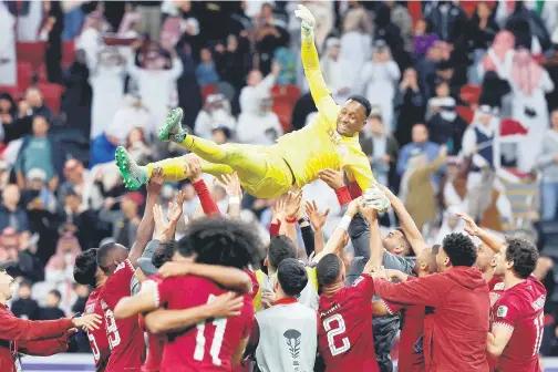  ?? — Gambar AFP ?? WIRA PASUKAN: Pemain Qatar melambungk­an Barsham ke udara sebagai tanda perwira pasukan selepas berjaya menepis tiga tendangan penalti pada perlawanan suku akhir Piala Asia 2023 menentang Uzbekistan di Stadium Al-Bayt di Doha.