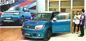  ?? FRIZAL/JAWA POS ?? PRIMADONA: Marketing Communicat­ion UMC Fransisca Juanda (kiri) dan Consultant Sales UMC Andik menunjukka­n Suzuki Ignis di showroom UMC A. Yani Surabaya kemarin (13/3).