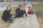  ?? KAREN DURRIE ?? Grace Willcocks, from left, and her children Levi, 11, Lily, 12, Prestley, 7, and Isabelle, 9, leave messages and hopscotch
directions on a sidewalk in Mckenzie Towne.