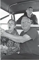  ?? PAUL A. SMITH ?? Megan Hartwig, 13, of Clintonvil­le reels in a coho salmon on Lake Michigan with the help of her father Jeff. Her brother Logan, 15, is also on the boat.