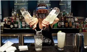  ?? AP ?? A bartender in Santa Clarita, California, mixes a drink while wearing a mask and face shield. Bars and restaurant­s across much of the state are closing again as coronaviru­s cases increase.