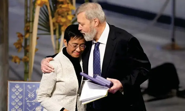  ?? ?? The Nobel peace prize winners, Dmitry Muratov, right, and Maria Ressa, embrace during the Oslo ceremony. Photograph: Alexander Zemlianich­enko/AP