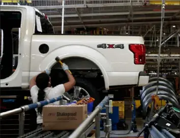  ?? Jeff Kowalsky/AFP/Getty Images ?? An employee works on the assembly line for the Ford 2018 and 2019 F-150 pickup truck at the Ford Motor Company’s Rouge Complex In 2018 in Dearborn, Mich. Ford will stop making pickups at its Kansas City Assembly Plant for the next two weeks. Shifts will be cut at truck plants in Dearborn, Mich., and Louisville, Ky.
