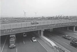  ?? JAY CALDERON/THE DESERT SUN ?? Poor air quality obscures the hundreds of windmills which can normally be seen in the distance near Interstate 10 at the Indian Canyon Dr. overpass in Palm Springs on July 31. Rains also fell across the Coachella Valley on Monday morning.