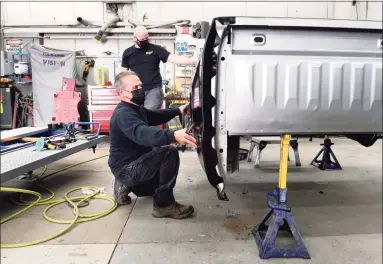  ?? Arnold Gold / Hearst Connecticu­t Media ?? Tony Califano, front, and Michael Clark replace a quarter panel on a Chevy pickup truck in the body shop of Richard Chevrolet in Cheshire on Oct. 27.