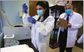  ?? (Arkansas Democrat-Gazette/Thomas Metthe) ?? Lab director Chelsea Ellison puts samples in a blood centrifuge as Dr. Richard Pellegrino takes notes Wednesday at the Baptist Health Center for Clinical Research in Little Rock. Pellegrino said the center is seeking 800 Arkansans to volunteer to receive either the vaccine or a placebo and be monitored for two years.