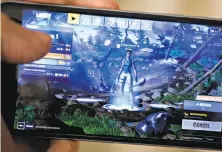  ?? Andrew Harrer / Bloomberg ?? “Fortnite,” seen on an iPhone, has turned into a phenomenon, on track to generate $2 billion for Epic Games, the company that Tim Sweeney founded in his parents’ basement.