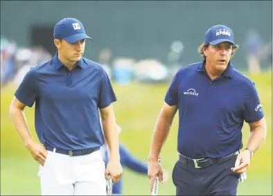  ?? Warren Little / Getty Images ?? Jordan Spieth, left, and Phil Mickelson walk on the 14th green during the second round of the 2018 U.S. Open at Shinnecock Hills Golf Club on Friday in Southampto­n, N.Y. Spieth continues to struggle on the golf course.