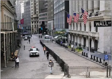  ?? (AP/Mark Lennihan) ?? A police car patrols Wednesday in front of the New York Stock Exchange. Stocks rose on renewed optimism about an agreement on additional economic stimulus measures.