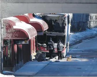  ??  ?? On Saturday, Transport Canada officials look at the damage where a double-decker city bus struck a transit shelter at the start of the afternoon rush hour on Friday in Ottawa.