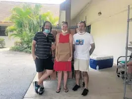  ?? BOCA HELPING HANDS PHOTOS ?? Jeff Rosenthal, Ashely Mattocks and Andy Willis hand out food pantry bags at the new Boca Helping Hands site in the Lantana area.