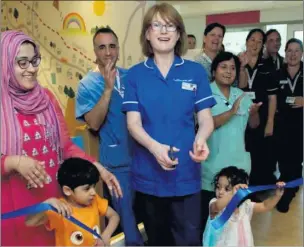  ??  ?? n OFFICIAL OPENING: Mary O’Callaghan (centre) with two young patients Zayd and Zara and their mother Nadia Faiz at the new Hillingdon Hospital children’s A&E. Left, bed bay areas have been widened and bright artwork added to make the unit more welcoming