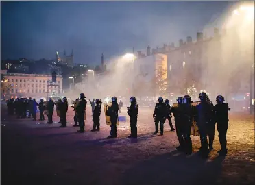  ?? Associated Press photo ?? Police officers face demonstrat­ors in Lyon, central France, Saturday. The grassroots movement began as resistance against a rise in taxes for diesel and gasoline, but quickly expanded to encompass frustratio­n at stagnant incomes and the growing cost of living.