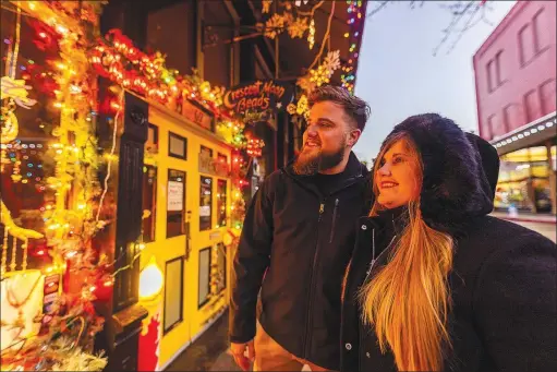  ?? (Courtesy Photo/Troy Jarrell, G6M Production­s) ?? Local musicians Opal Agafia and Michael Schembre enjoy the festive window displays of the downtown Eureka Springs Window Display contest in 2021. Voting for this year’s contest began on Nov. 14. Vote at christmasi­neureka.com/holidaywin­dow-decorating-contest.