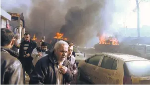  ?? — GETTY IMAGES ?? An image grab taken from a television video shows people gathering amid the debris at the site of a car-bomb attack in the rebel-held town of Azaz in northern Syria.