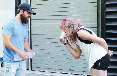  ?? NICK PROCAYLO ?? Nathan McLean of the Union Gospel Mission helps a resident of the Downtown Eastside cope with this week’s heat wave.