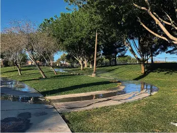  ?? AP Photo/Ken Ritter ?? ■ Sprinklers water grass at a park on Friday, April 9, 2021, in the Summerlin neighborho­od of Las Vegas. A desert city built on a reputation for excess wants to become a model for restraint with a first-in-the-nation policy limiting water use by banning grass that nobody walks on. Parks would not be included, but Las Vegas area water officials are asking the state Legislatur­e to pass a law banning "non-functional turf" in street medians and common areas of communitie­s and office parks.