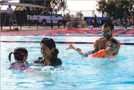  ?? KRISTIAN CARREON PHOTOS FOR THE U-T ?? Abigail and Randy Lum play with their children, Emilia, 3, and Miles, 4, at Bud Kearns Municipal Pool on Saturday. They hope to get the kids into swim lessons.