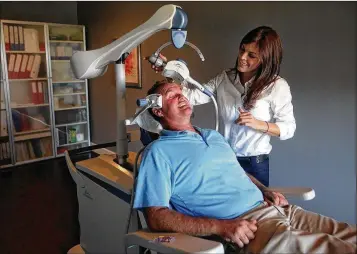  ?? BRUCE R. BENNETT / THE PALM BEACH POST ?? Kristie DeBlasio demonstrat­es Transcrani­al Magnetic Stimulatio­n on a patient in Juno Beach in 2012. Jupiter psychiatri­st Dr. Edward Zawadzki said TMS activates neurons in the brain’s dorsolater­al prefrontal cortex by forcing them to fire and release their mood-altering chemicals.