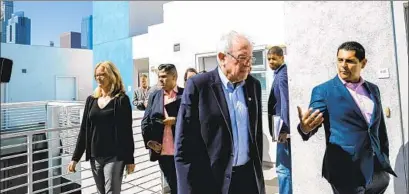  ?? Marcus Yam Los Angeles Times ?? SEN. BERNIE SANDERS (I-Vt.), center, tours a building in downtown L.A. developed by Skid Row Housing Trust in 2019.