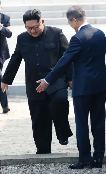  ?? Picture: AFP ?? South Korea's President Moon Jae-in (right) gestures to North Korea's leader Kim Jong-un to step over the Military Demarcatio­n Line that divides their countries.