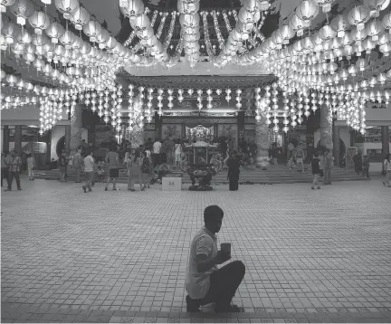  ?? JOSHUA PAUL/AP FILES ?? A tourist takes a selfie under illuminate­d traditiona­l Chinese lanterns on the eve of Lunar New Year in Kuala Lumpur, Malaysia in February 2016. Muslims are becoming key economic drivers in tourism.