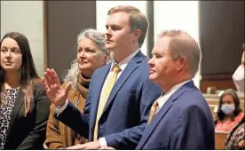  ?? Jeremy stewart ?? Wayne Wright Gammon III (center) is sworn in as a new lawyer during a ceremony in Polk County Superior Court while standing with his mother, Alicia Gammon (left), and his father, W. Wright Gammon Jr., at the Polk County Courthouse on Tuesday, Nov. 30, 2021.
