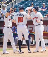  ?? JIM THOMPSON/JOURNAL ?? Jordan Patterson celebrates his three-run homer with teammates Noel Cuevas, left, and Ryan McMahon. Patterson drove in four runs as the Isotopes rallied for a 7-6, 12-inning win.