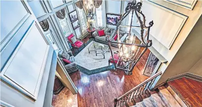  ?? COLDWELL BANKER R.M.R. REAL ESTATE PHOTOS ?? The staircase is open to the airy living room with 20-foot ceilings, hardwood floors and 10 separate windows.