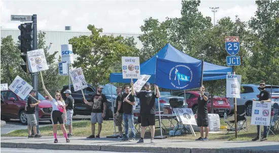  ?? PHOTO AGENCE QMI, JOËL LEMAY ?? Des employés du Port de Montréal en grève devant la maison des débardeurs sur la rue Notre-Dame Ouest, hier, à Montréal.