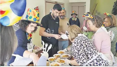  ?? ALBERTO DOMÍNGUEZ ?? Reparto de las raciones de paella de carnaval en la sede de la asociación de vecinos.