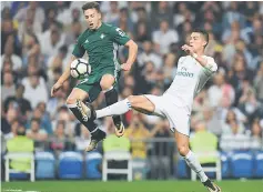  ??  ?? Real Madrid’s forward from Portugal Cristiano Ronaldo (right) vies with Real Betis’ forward from Spain Francis Guerrero during the Spanish league football match Real Madrid CF against Real Betis at the Santiago Bernabeu stadium in Madrid on Sept 20...