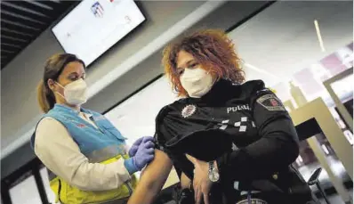  ?? José Luis Roca ?? Vacunación de una policía en las instalacio­nes habilitada­s en el estadio Wanda Metropolit­ano, ayer.