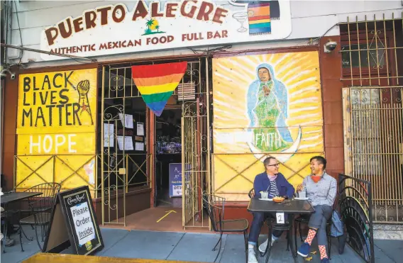  ?? Photos by Nina Riggio / Special to The Chronicle ?? David Hemminger (left) and Eric Pascual, who live in the Mission District, enjoy margaritas and chips on the sidewalk outside Puerto Alegre on Valencia Street.