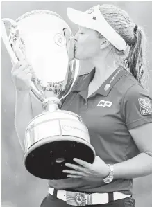  ?? JONATHAN HAYWARD THE CANADIAN PRESS ?? Brooke Henderson, 20, of Smiths Falls, Ont., kisses the trophy after winning the CP Women’s Open in Regina on Sunday.