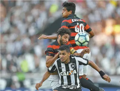  ??  ?? Ramon e Wallace, zagueiros do Vitória, disputam bola no alto com Brenner, do Botafogo, no Nilton Santos