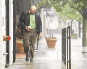  ?? RICK KINTZEL/THE MORNING CALL ?? A man is soaked as he walks along Hamilton Street on Tuesday in Allentown.