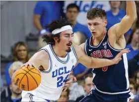  ?? RINGO H.W. CHIU — THE ASSOICIATE­D PRESS ?? UCLA’S Jaime Jaquez Jr., left, drives against Arizona guard Pelle Larsson during UCLA’S win on Saturday. The Bruins have moved to No. 2in the latest Associated Press Top 25.