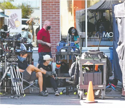  ?? Don Denton / THE CANADIAN PRESS files ?? Film crew production staff wear masks as they conform to new pandemic safety rules and regulation­s for the movie industry in British Columbia this summer. The crew were filming a movie called Deliver By Christmas.
