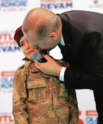  ?? FOTO: REX FEATURES ?? Erdogan küsst während des Parteitags der AKP ein Mädchen in einer Soldatenun­iform.