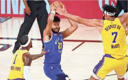  ?? KIM KLEMENT/USA TODAY SPORTS ?? Nuggets guard Jamal Murray tries to control the ball while being covered by Lakers guard Kentavious Caldwell-pope, left, and center Javale Mcgee in Game 1 Western Conference Finals.