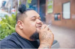  ?? DAVID ROWLAND/AP ?? A smoker enjoys lighting up Thursday in Auckland, New Zealand. The government believes it has come up with a plan to end tobacco smoking — lifetime bans.