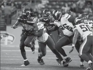  ?? The Associated Press ?? YARDS AFTER CONTACT: Seattle running back Alex Collins, left, runs against the Minnesota Vikings in the second half of an NFL preseason game Friday night in Seattle. The former Arkansas Razorback had 58 yards on 10 carries in Seattle’s 20-13 win.