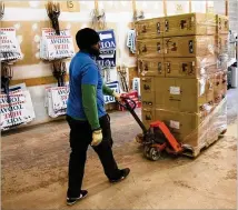  ?? PHOTOS CONTRIBUTE­D BY PHIL SKINNER ?? Phillip Simmons unloads a stacked pallet Monday from the largest shipment of Georgia’s new secure paper-ballot voting machines so far — more than 2,800 of the machines at the DeKalb County Voter Registrati­on and Elections offices.