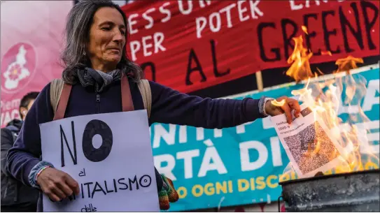  ?? ?? Protesters against vaccine passports burn facsimiles bearing the swastika symbol above the barcode in Turin, Italy