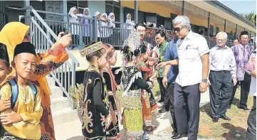  ??  ?? Khir being greeted by the pupils of Sekolah Kebangsaan Haji Bujang Rangawan Putin in Sadong Jaya yesterday�� — Bernama photo