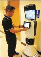  ??  ?? Caezar Jara, stroke program coordinato­r for Adventist Health and Rideout Hospital, enters informatio­n into “Rita,” a mobile robot which allows the Yuba City hospital to beam in a neurologis­t located in Sacramento.