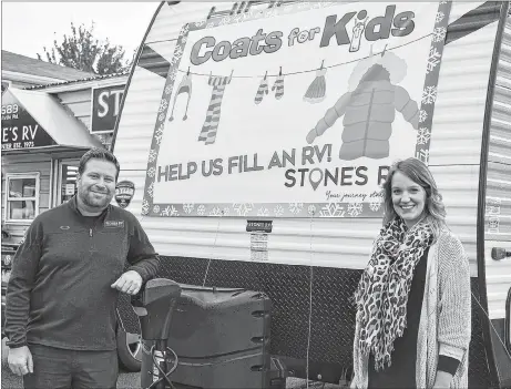  ?? ADAM MACINNIS/THE NEWS ?? Jonathan Stone, owner of Stones RV, and Catherine Millen, marketing co-ordinator for the company, stand beside an RV they hope to fill with donations for Coats for Kids.