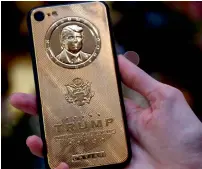  ?? — AFP ?? Caviar Phones, a Russian-Italian company specialisi­ng in smartphone customisat­ion, displays a gold-plated iPhone 7 bearing an image of US president-elect Donald Trump in its boutique outside Moscow.